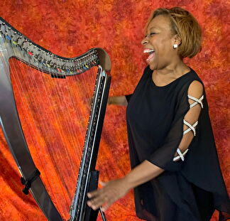 Robbin laughs next to her harp