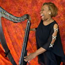 Robbin laughs next to her harp