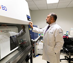 Dr. Sadiq looks at a piece of equioment