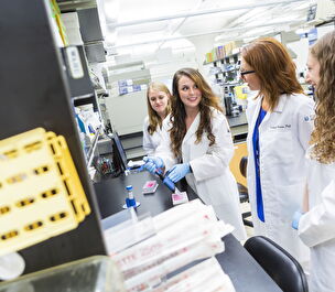 4 scientists smile at the counter